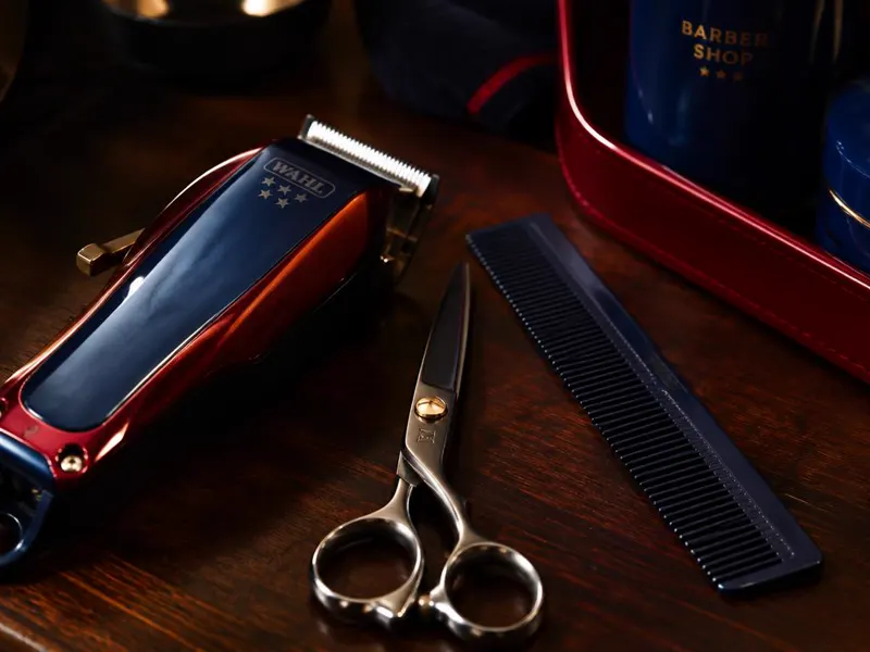 Máquina, tijeras y peine de barbero sobre la mesa de trabajo